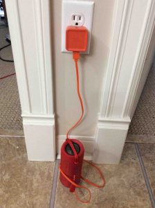 Picture of the JBL Flip 3 Bluetooth speaker, connected to AC power. 
