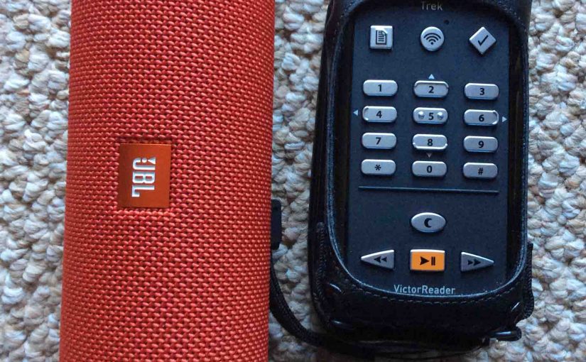 Picture of a JBL Flip 3 Bluetooth speaker alongside a Victor Reader Trek talking GPS audio media player.