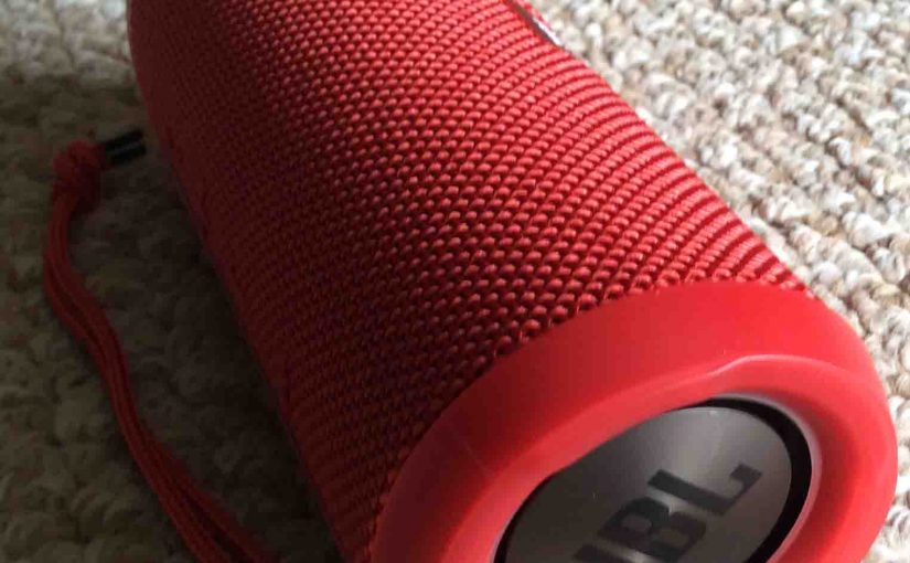 Picture of the JBL Flip 3 wireless speaker, red version, showing its back and left end passive radiator.