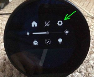 Picture of the speaker displaying its Main Menu screen, with the -Settings- button highlighted. Echo Spot Firmware Update.