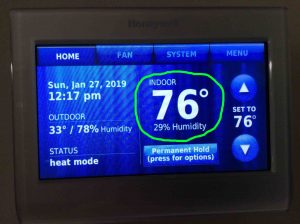 Picture of a Honeywell thermostat screen face, displaying its -Home- page, showing the current indoor temperature to be 76 degrees.