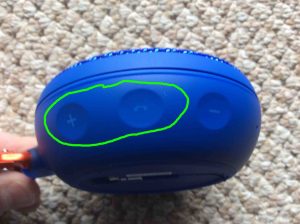Picture of the JBL Clip 2 Bluetooth speaker, side view, showing the Phone and Volume Up buttons circled. JBL Clip 2 Reset Button Location.
