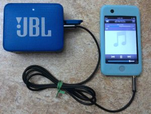 Picture of the speaker, connected via its AUX input to an iPod Touch portable media player. 