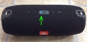 Picture of the JBL Xtreme Bluetooth speaker powered on and paired, with its blue glowing Power button highlighted.
