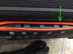 Picture of the JBL Xtreme Bluetooth speaker, rear view, showing its ports zipper open, with the power input charging port highlighted.