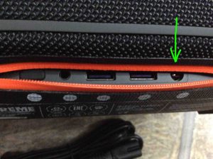 Picture of the JBL Extreme Bluetooth speaker, rear view, showing its ports zipper open, with the power input charging port highlighted.