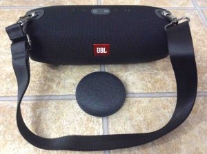 Picture of the Xtreme 1 JBL Bluetooth speaker and its carrying strap, along with the Mini Google Home smart speaker.