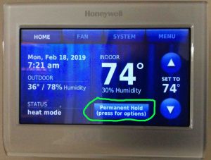 Picture of a typical Honeywell thermostat displaying its -Home- page, with the -Permanent Hold, Press for More Options- button circled.
