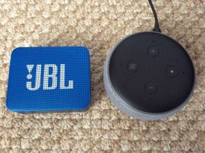 Picture of the JBL Go 2 Bluetooth speaker alongside an Alexa Echo Dot 3rd generation model.