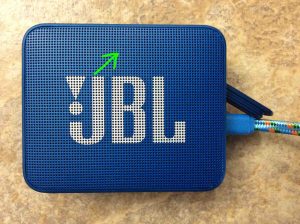 Picture of the JBL Go 2 speaker, fully charged, powered OFF, but is still connected to charger power. The status lamp is not glowing at all, and is highlighted.