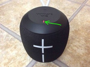 Picture of the front top of this mini speaker, with the -Power- button glowing steady red and highlighted.