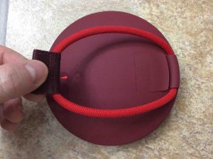 Picture of the UE Roll speaker, back view, showing the built in bungee loosened. UE Roll 1 Charging.