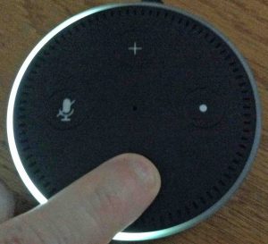 Picture of the top of the Echo Dot 2 speaker, showing the -Lower Volume- button being pressed.