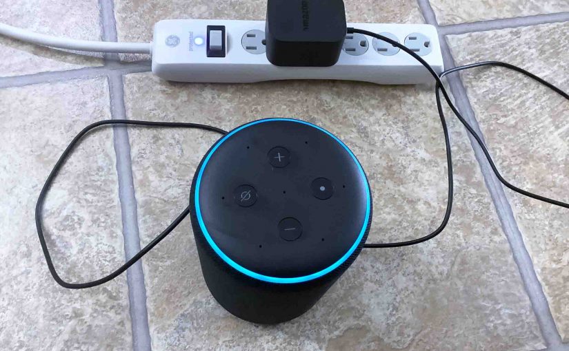Top view of the Amazon Echo 3rd Gen Alexa speaker, shown connected to AC power and booting.