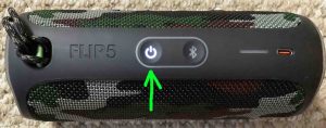 Picture of the top of the JBL Flip 5 speaker, powered ON, not paired, showing the glowing Power button highlighted.