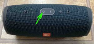 Picture of the JBL Charge 4 speaker, powered OFF, with its Power button highlighted.