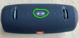 Top view of the speaker, showing the -Power- and -Connect- buttons glowing during reset, circled.