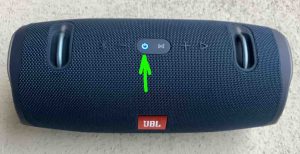 Top view of the JBL Xtreme 2 power bank speaker, showing the -Power- button highlighted and glowing blue, meaning that the speaker is ON and paired.