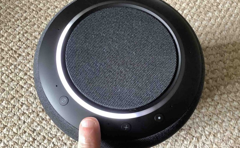 Top view picture of the Alexa Echo Studio speaker, showing the -Volume DOWN- button being pressed.