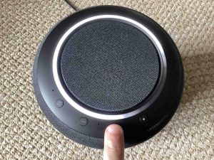 Top view picture of the Amazon Echo Studio speaker, showing the -Volume UP- button being pressed.
