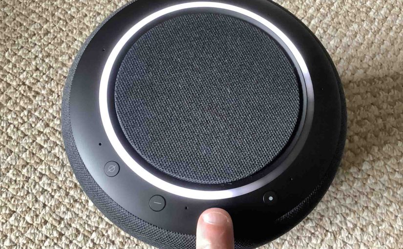 Top view picture of the Amazon Echo Studio speaker, showing the -Volume UP- button being pressed.