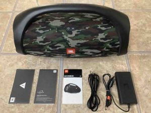 JBL Boombox speaker along with included charger and user documents.