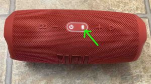 Top view of the JBL Charge 5 wireless speaker, showing the -Power- and -Bluetooth- buttons lit.