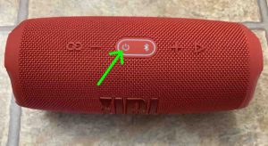 Top view picture of a common JBL Bluetooth speaker, showing the -Power- button when the unit is OFF.