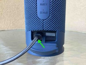Picture of a USB-C power cable inserted into the speaker's charging port.