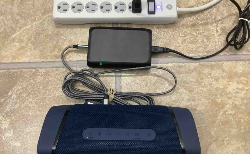 Picture of the Sony SRS XB33 speaker, connected to charger and charging.