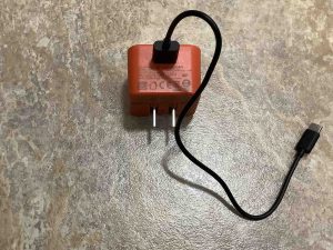 Picture of a USB-A JBL power adapter with a cable plugged into its USB-A output port.