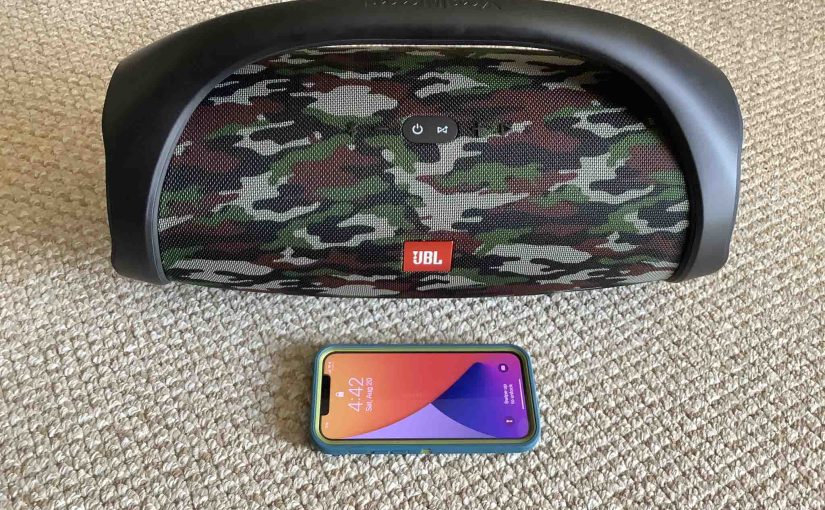 Picture of the JBL Boombox speaker behind an iPhone.