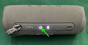 Picture of the glowing -Power- button on the JBL Bluetooth speaker.