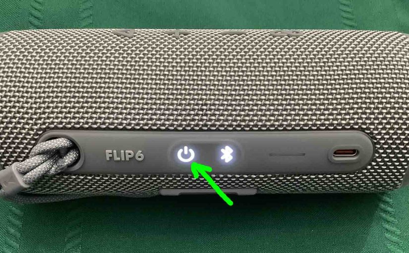 Picture of the glowing -Power- button on the JBL Flip 6 wireless speaker.
