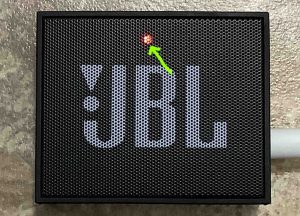 Picture of the glowing red lamp on the JBL Go speaker while charging. 