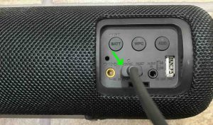 Picture of a USB charging cable inserted into the speaker's DC input port. 