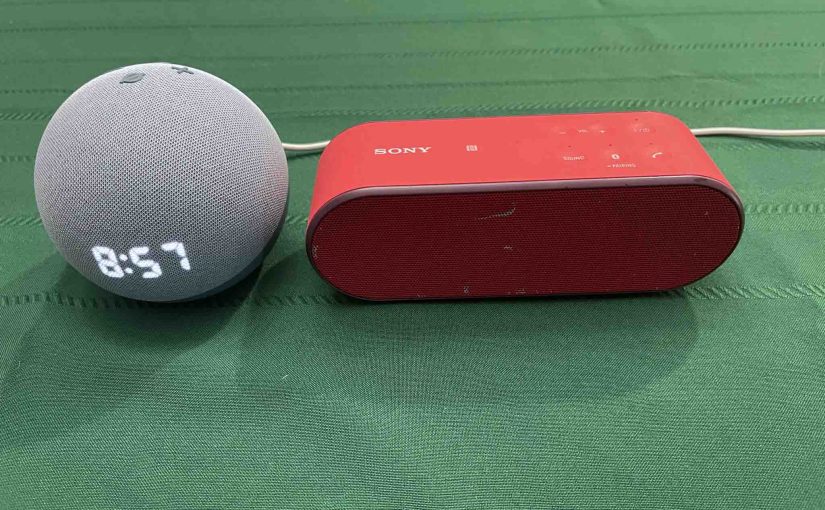 Picture of an Echo Dot 4 clock speaker beside the Sony SRS X2 Bluetooth speaker.