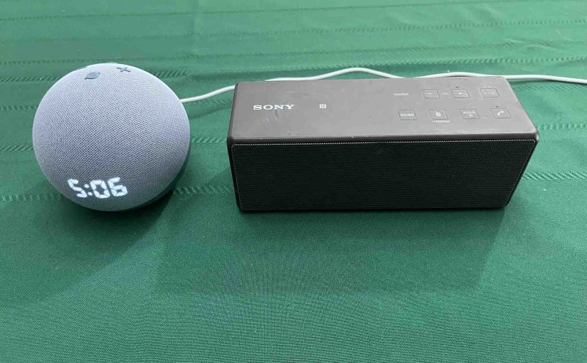 Picture of an Echo Dot 4 clock speaker beside the Sony SRS X3 BT speaker.
