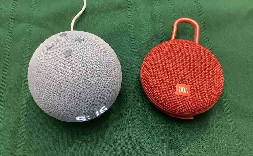 Picture of an Echo Dot 4 clock speaker alongside a JBL Clip 3 BT speaker.