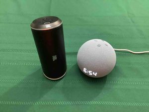 Picture of the Echo Dot 4 smart speaker with clock alongside the JBL Flip Bluetooth speaker. Battery Capacity mAh.