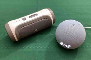 Picture of the JBL Charge 1 Bluetooth speaker alongside an Echo Dot 4 clock speaker.