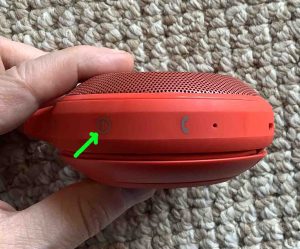 Picture of the Power button on the left side of the JBL Clip 1 speaker.