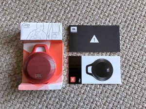 Picture of the JBL Clip speaker spread out with its packaging.