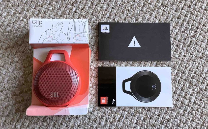 Picture of the JBL Clip speaker spread out with its packaging.