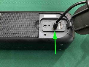 Picture of a power cable correctly inserted into the speaker's power input port.