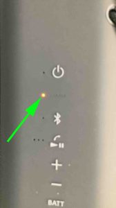 Picture of the orange glowing CHARGE indicator light on the Sony XE200.