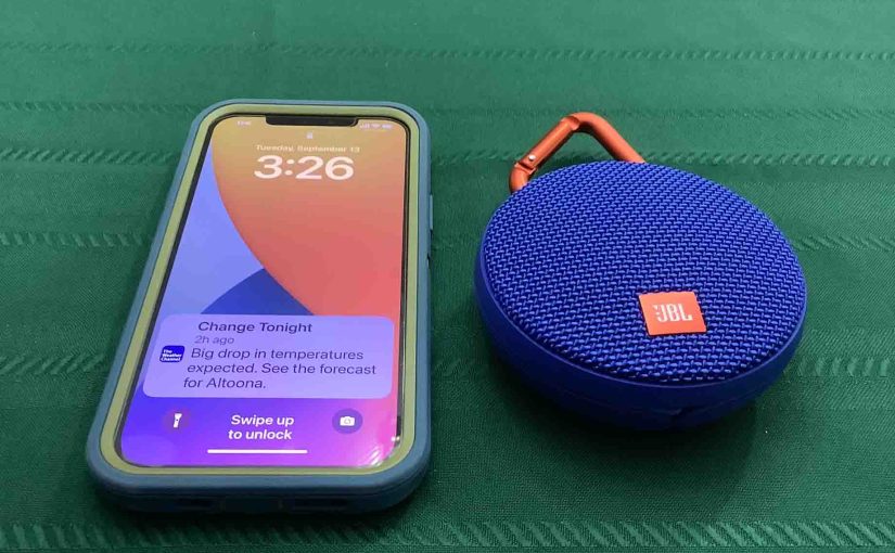 Picture of an iPhone beside a JBL Clip 2 speaker.