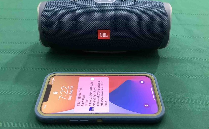Picture of an iPhone in Front of the JBL Charge 4 speaker.