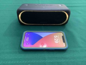 Picture of an iPhone in front of the Sony SRS XB30 speaker.