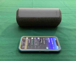 Picture of an iPhone in front of the Sony SRS XE300 Bluetooth speaker.